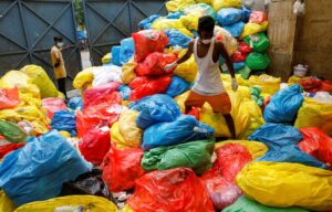 A waste collector walks over disposed medical waste bags inside a rubbish dump outside a hospital, during the coronavirus disease (COVID-19) outbreak, in New Delhi, India, July 17, 2020. REUTERS/Adnan Abidi     SEARCH "COVID-19 MEDICAL WASTE" FOR THIS STO